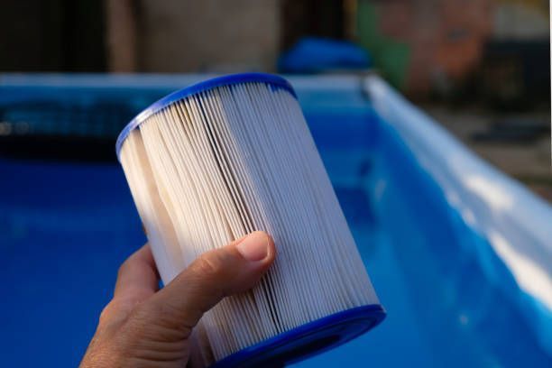 A Person Is Holding a Filter in Front of A Swimming Pool - Provo UT - Spa Doctor