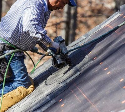 Roofing Contractor — Worker Using Nail Gun to Secure Shingles in Augusta, GA