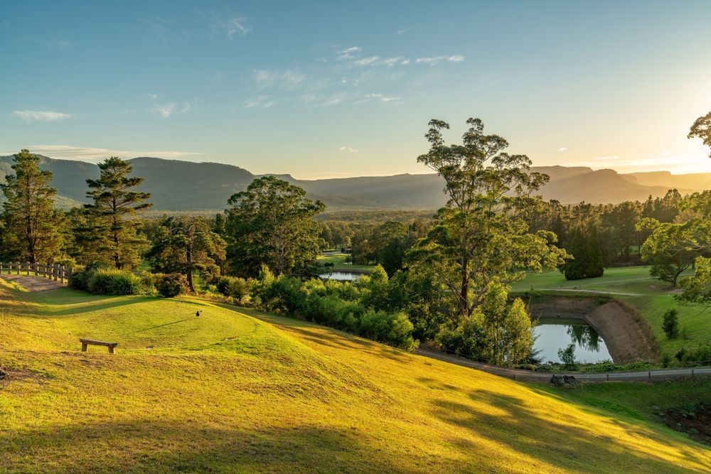 Green Hills with Trees, Ponds, and Distant Mountains Under a Sunny Sky — J&C Quality Construction in Southern Highlands, NSW