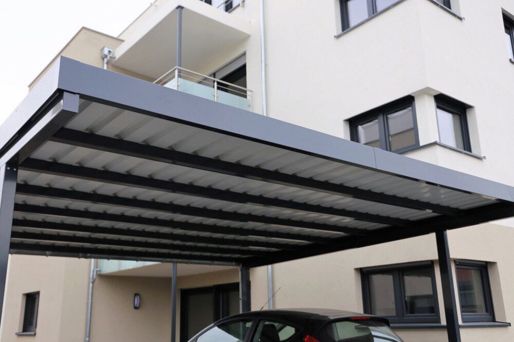 Grey Carport Sheltering a Black Car — J&C Quality Construction in Canberra, ACT