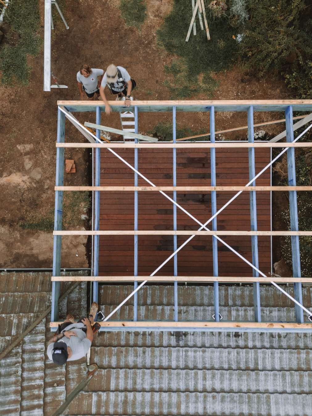 Construction Workers Building Roof Frame on Top of a Tile Roof — J&C Quality Construction in Goulburn, NSW