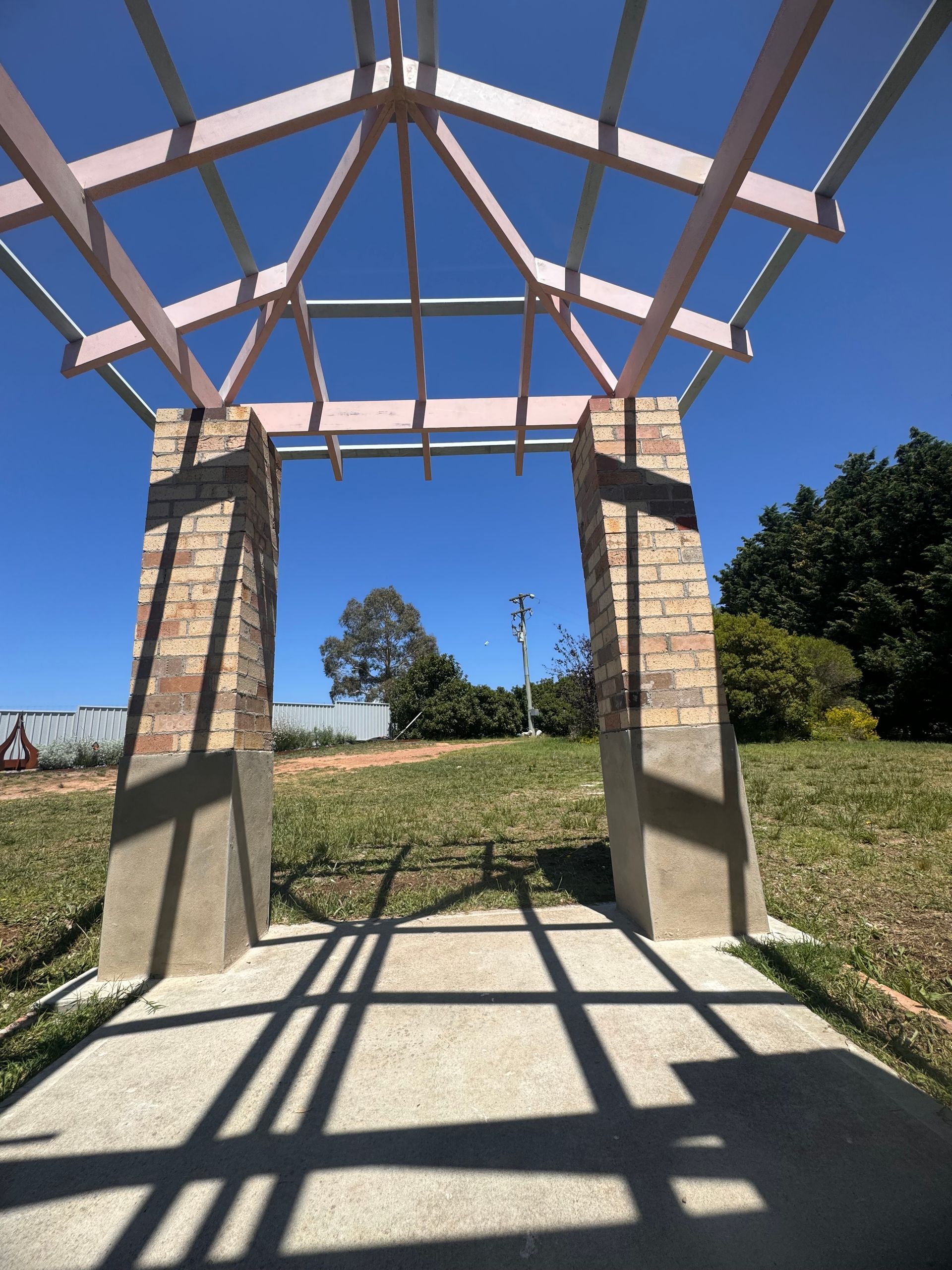 Arched Brick Entrance With Shadows on a Concrete Path — J&C Quality Construction in Goulburn, NSW