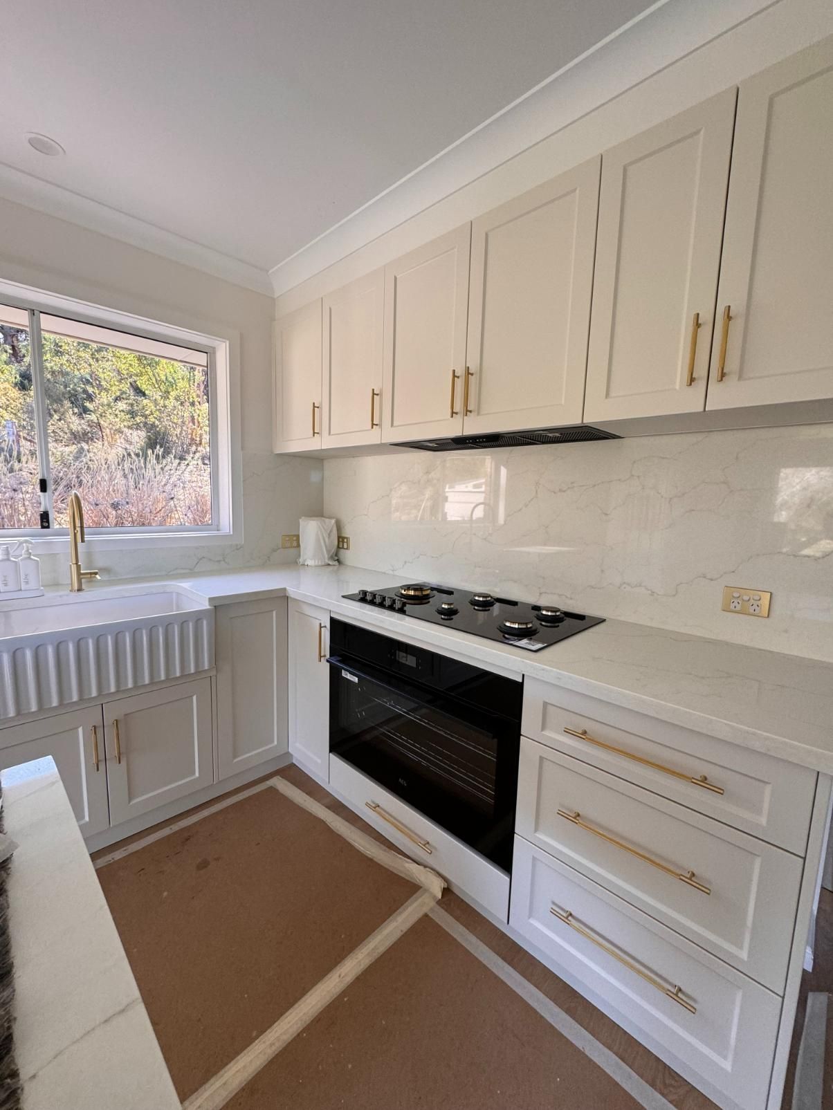 A Modern White Kitchen With Gold Hardware — J&C Quality Construction in Goulburn, NSW