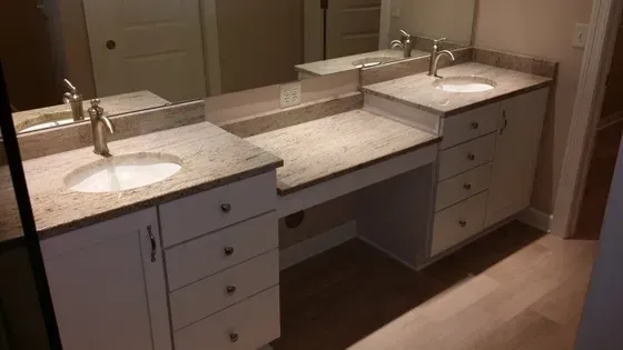 Bathroom vanity with two sinks, drawers, and counter space under a large mirror.