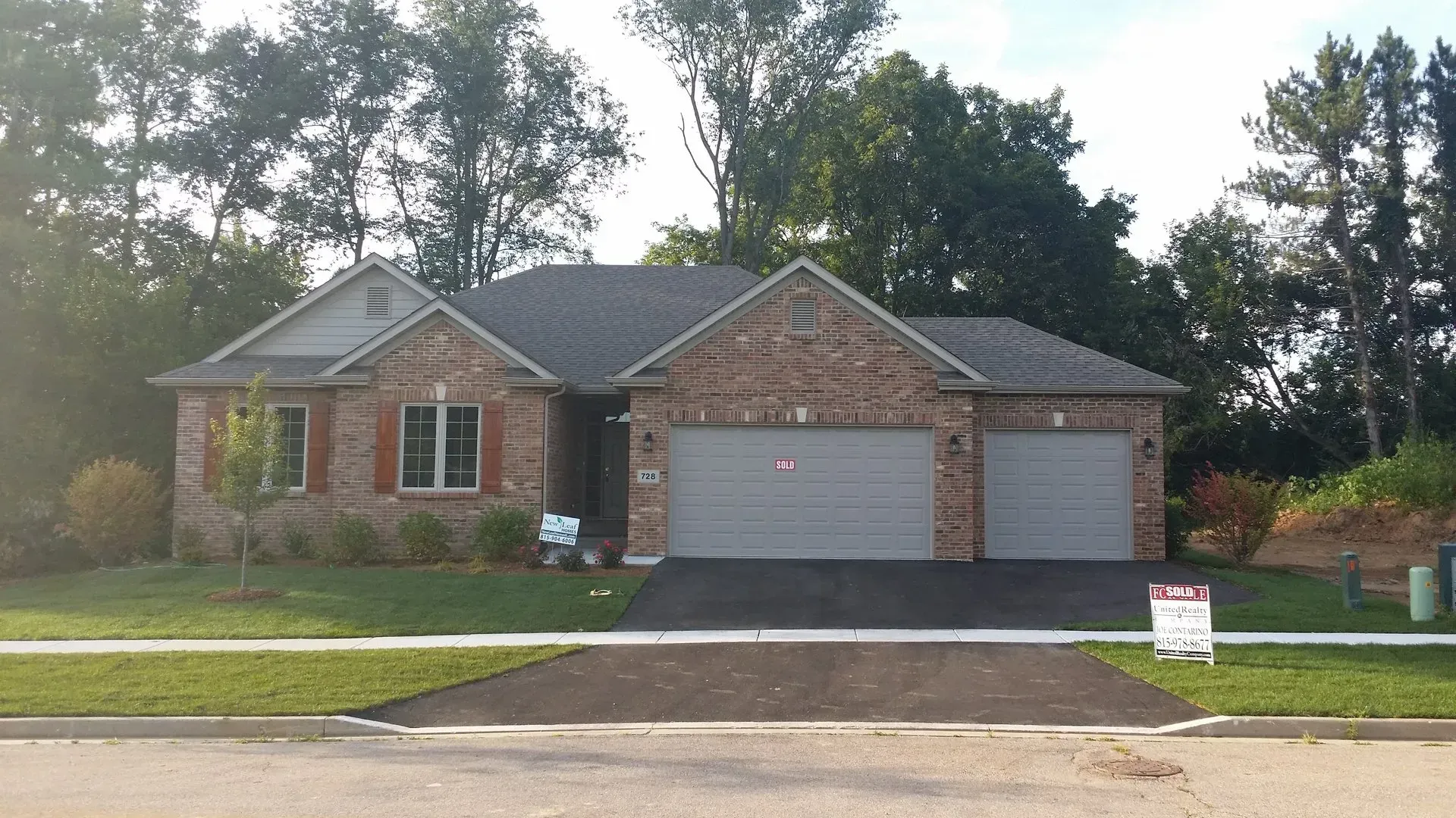 Ranch-style brick house with two-car garage, gray doors, and a