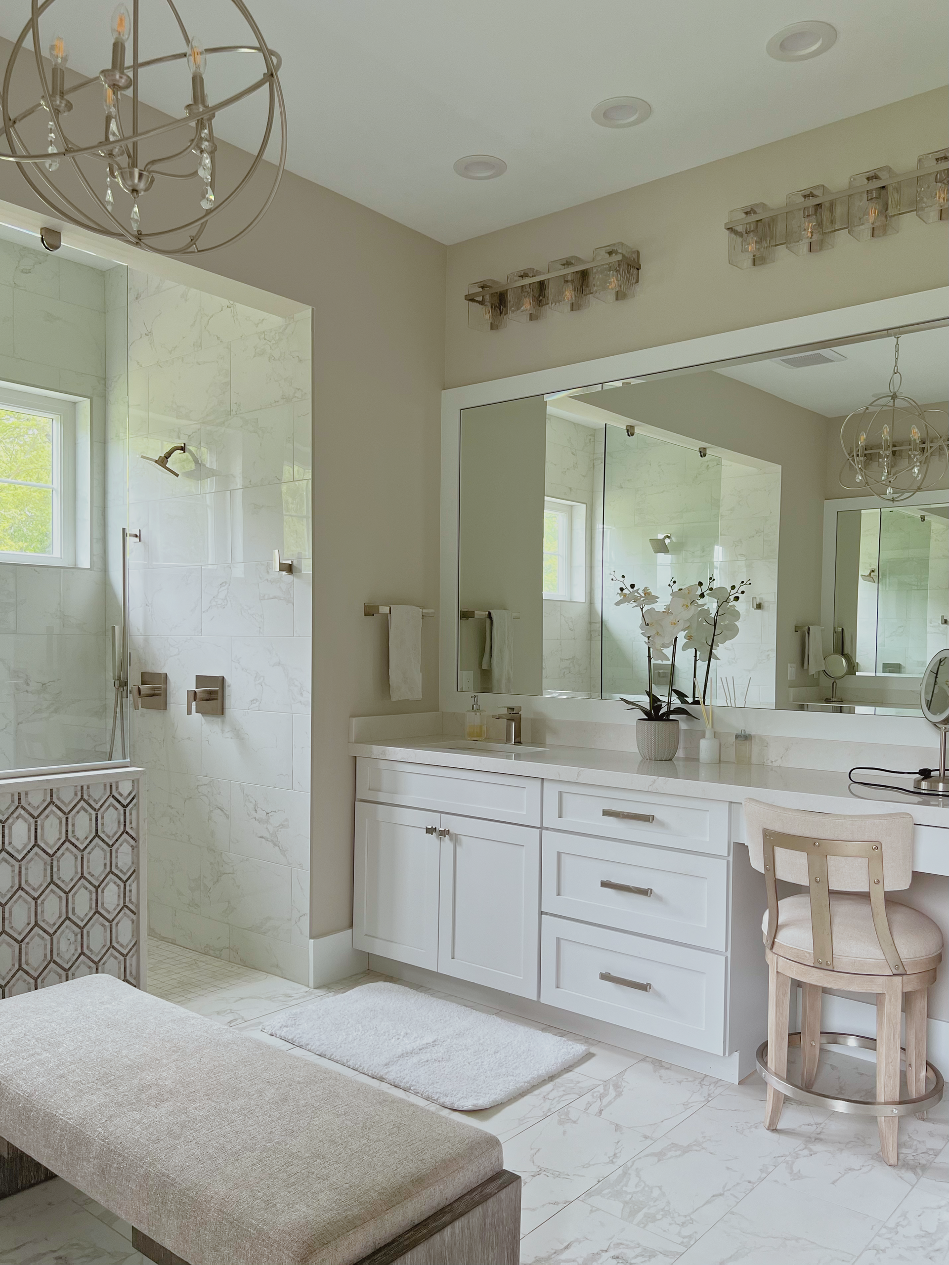 Elegant white bathroom with marble, a vanity, and a shower.