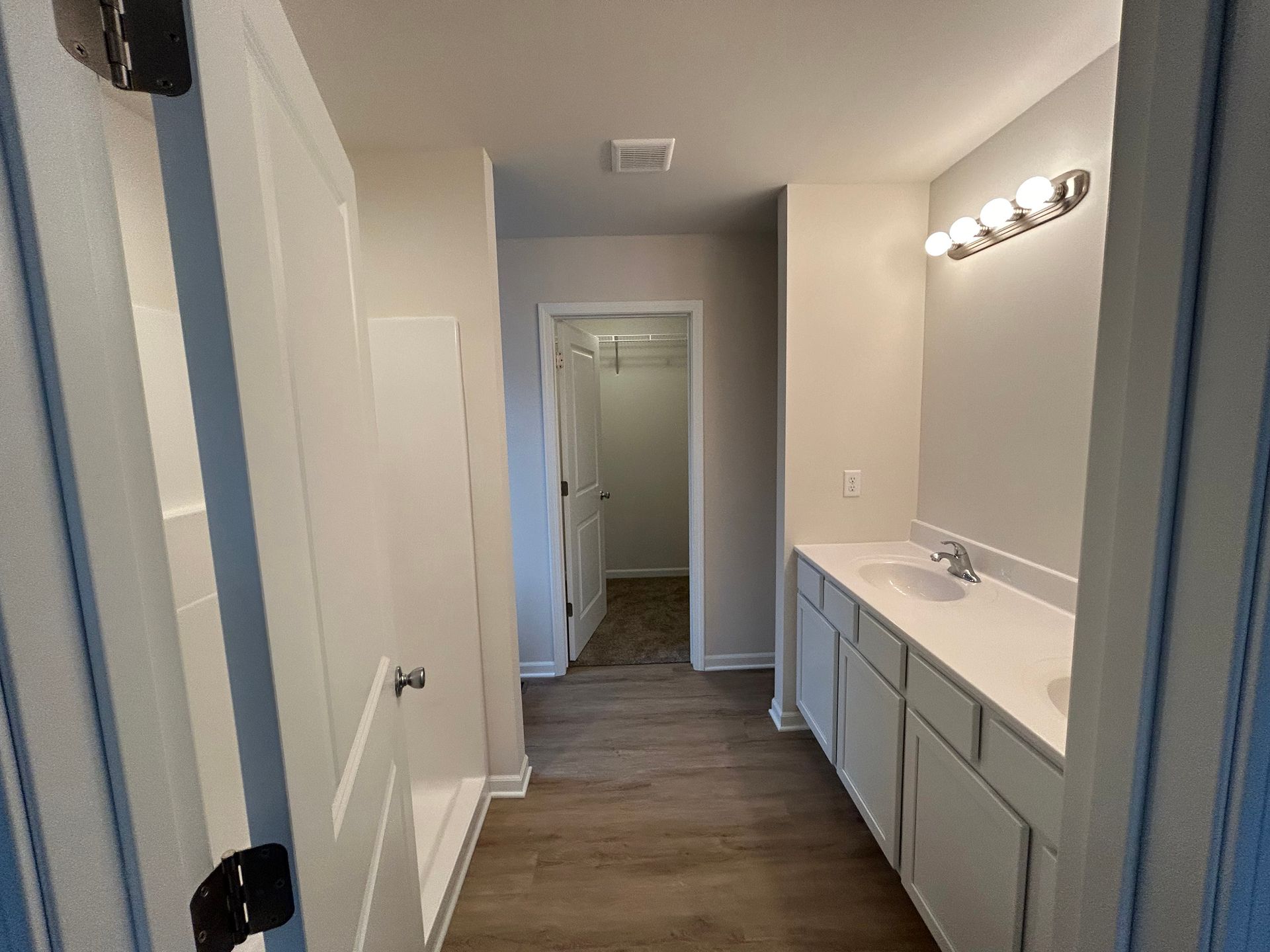 Bathroom with white vanity, sink, light fixture, and open closet.
