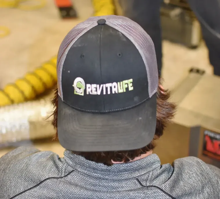 A person wearing a black and gray baseball cap with a