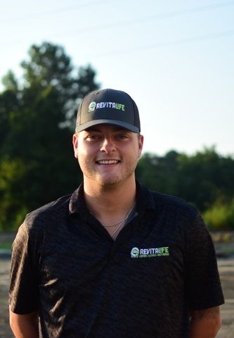 A smiling person wearing a black 