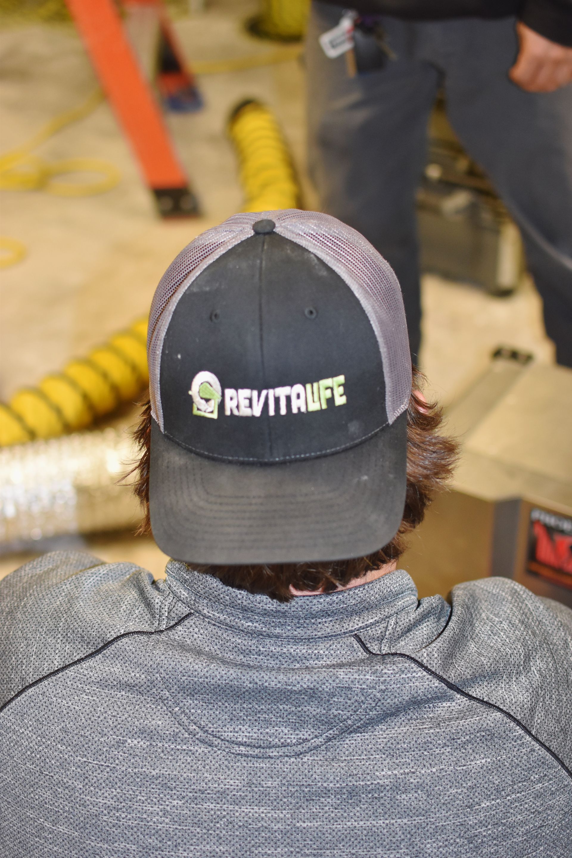 A person wearing a black and gray baseball cap with a