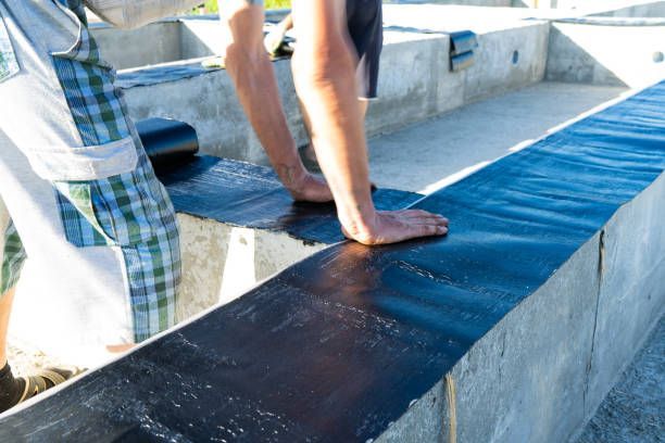 A person is standing on a concrete surface with their foot on it.