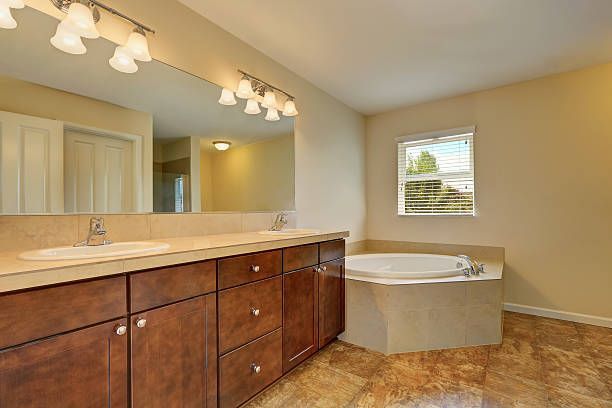 A bathroom with two sinks , a tub and a large mirror.