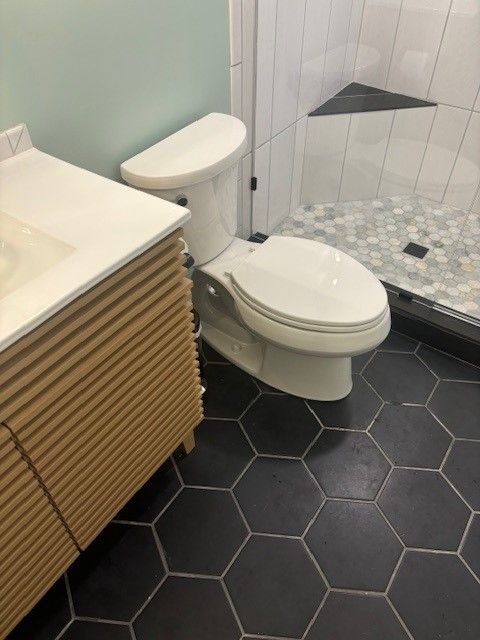 A bathroom with a toilet a sink and a shower