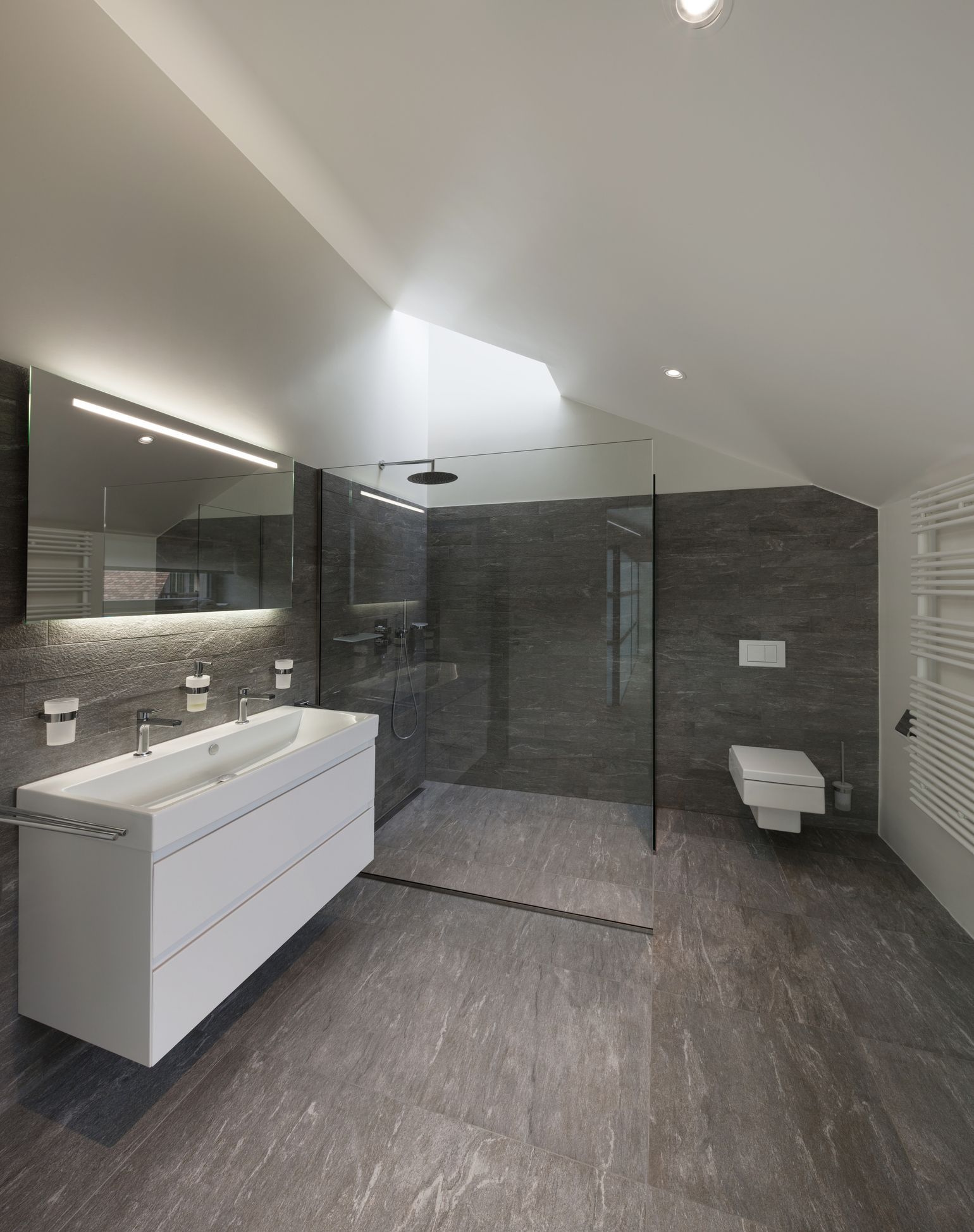 A bathroom with a walk in shower and a sink