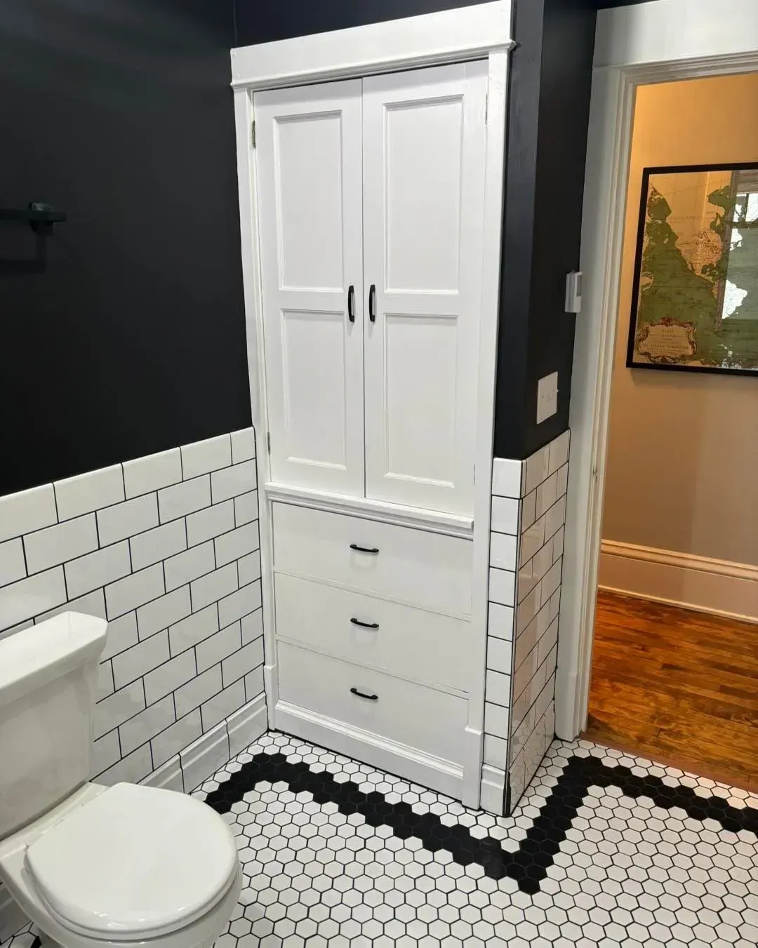A bathroom with black and white tiles and a toilet