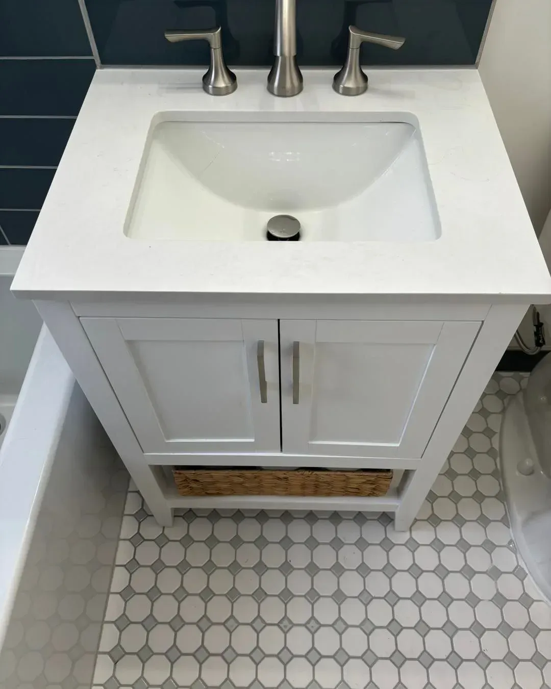 A bathroom sink with a basket underneath it