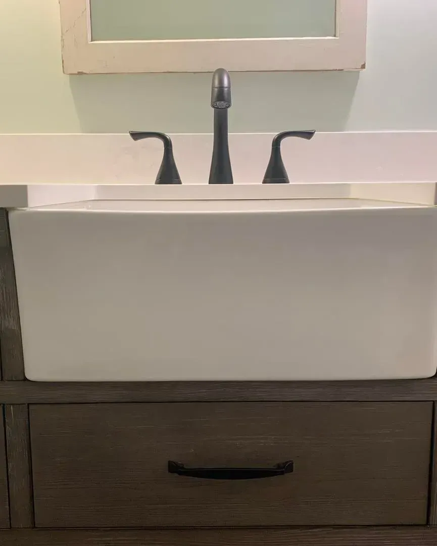 A bathroom sink with a mirror above it and a drawer underneath it.