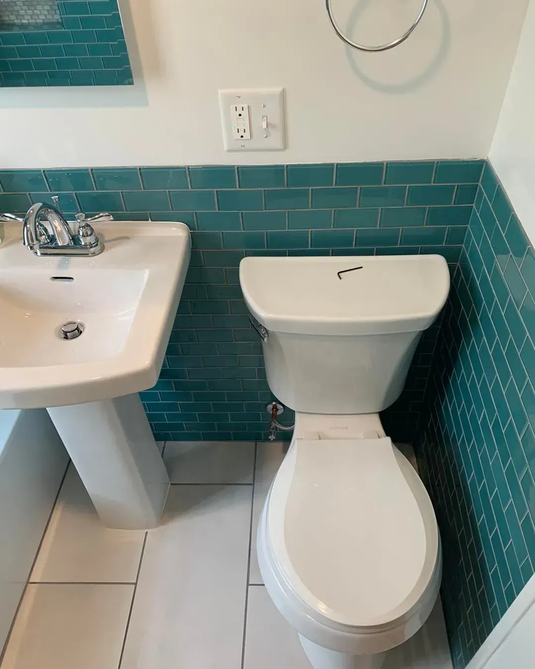 A bathroom with a toilet a sink and a mirror