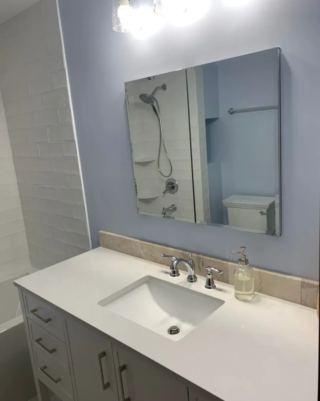 A bathroom with a sink a mirror and a toilet