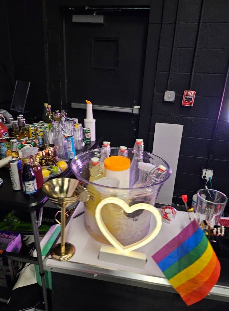 A table with a heart shaped light and a rainbow flag on it.