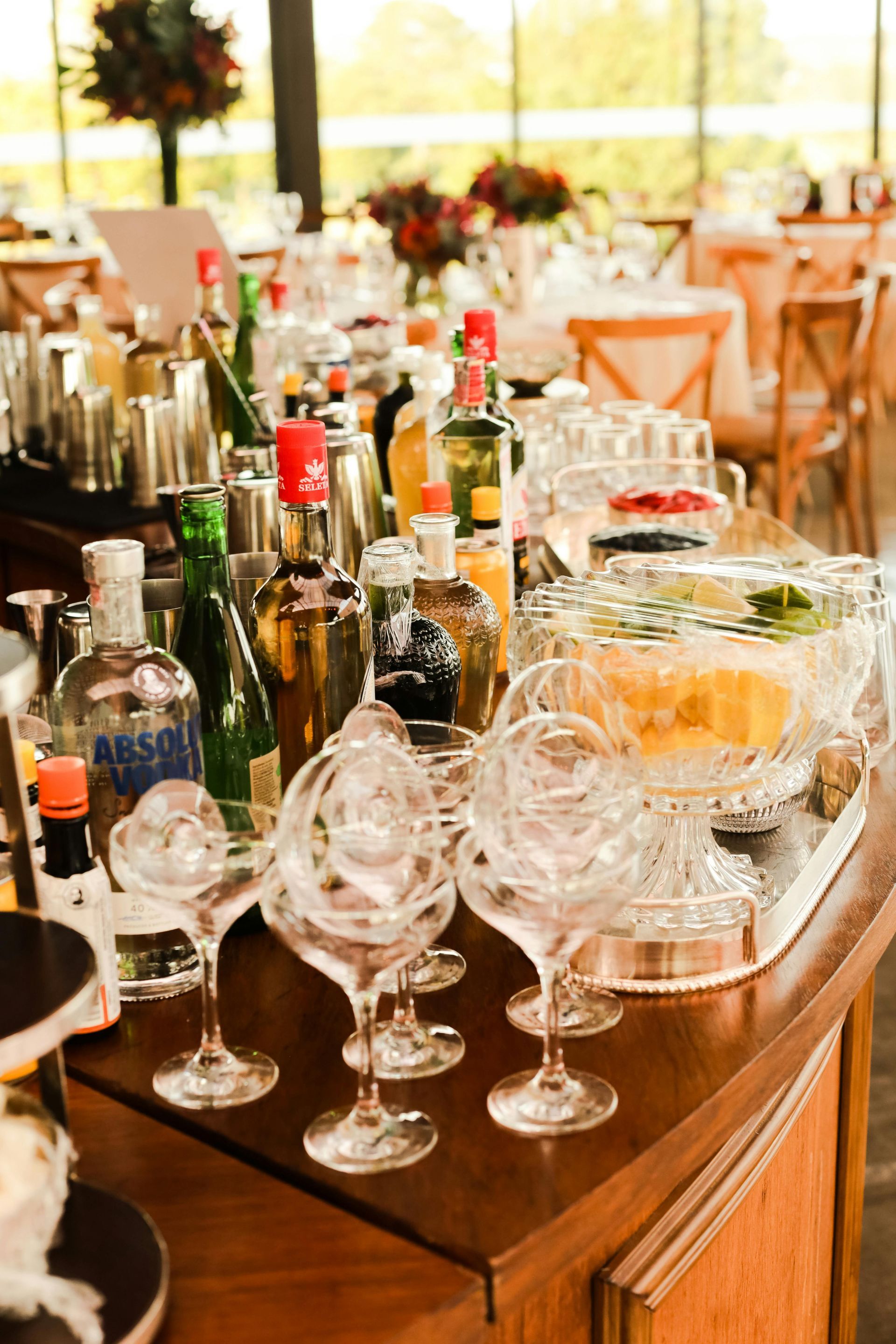 A bar with a lot of bottles and glasses on it.