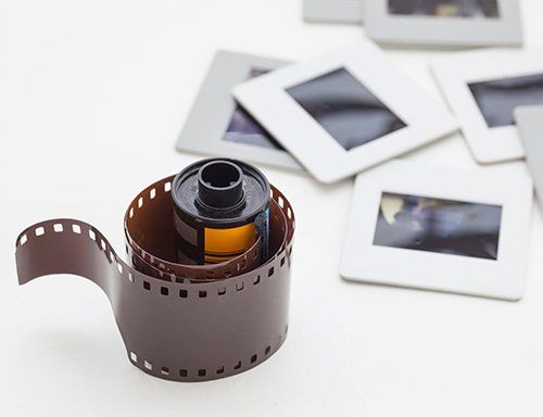 A roll of film is sitting on top of a pile of slides.