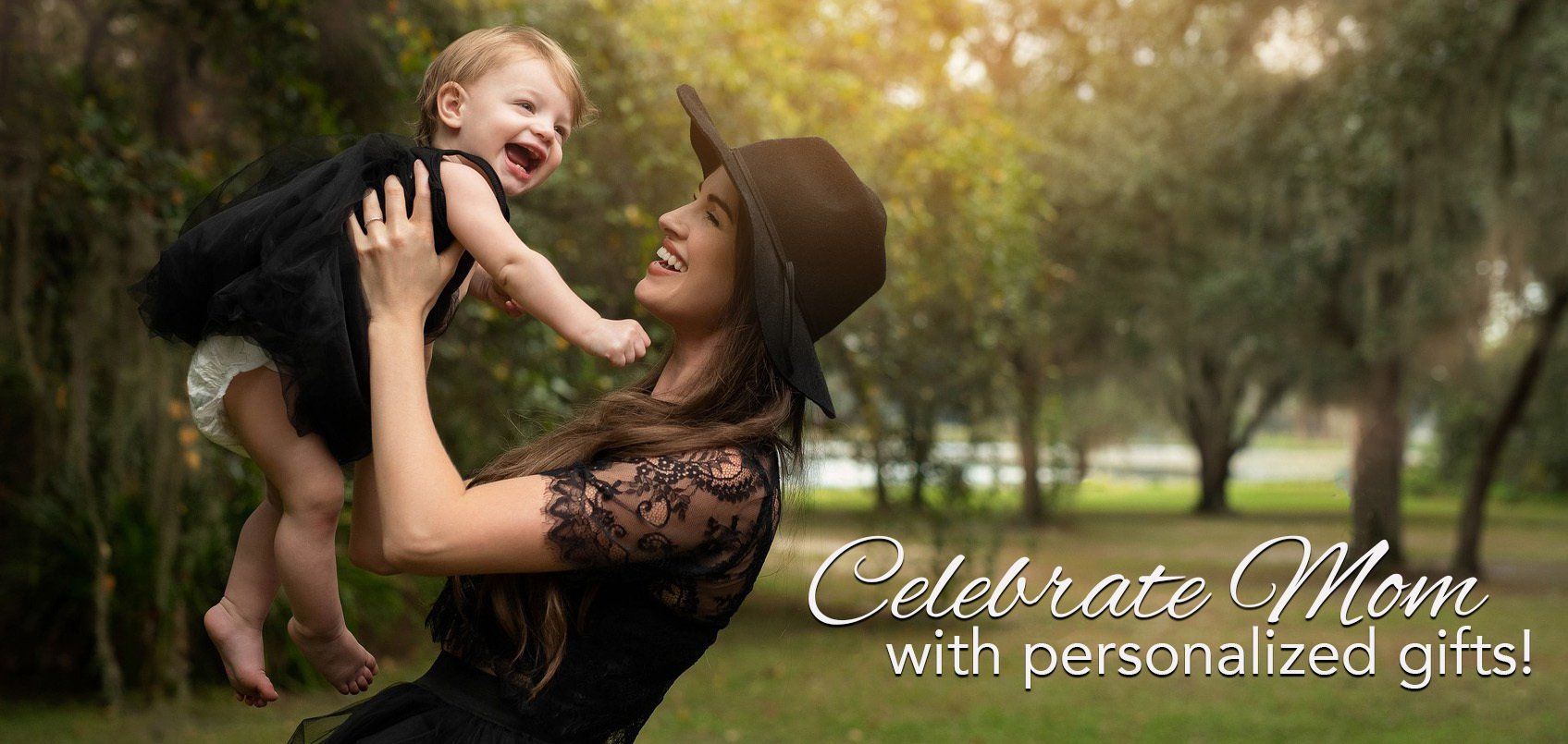 A woman is holding a baby in her arms in a park.