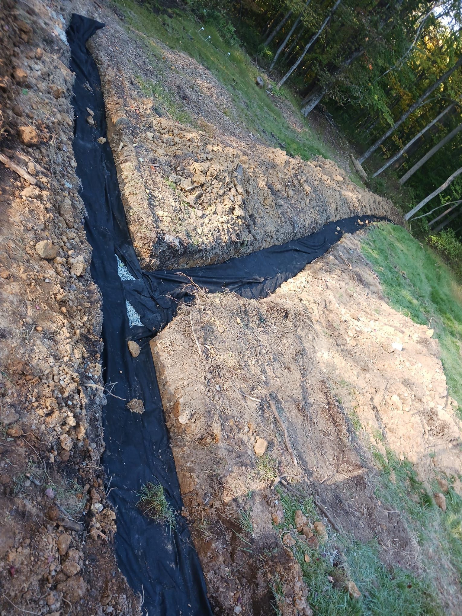 A black tarp is laying on top of a pile of dirt.