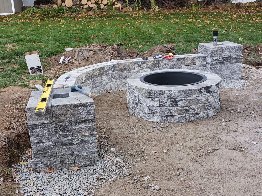 A fire pit is being built in a backyard.