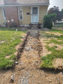 A dirt path leading to the front door of a house.
