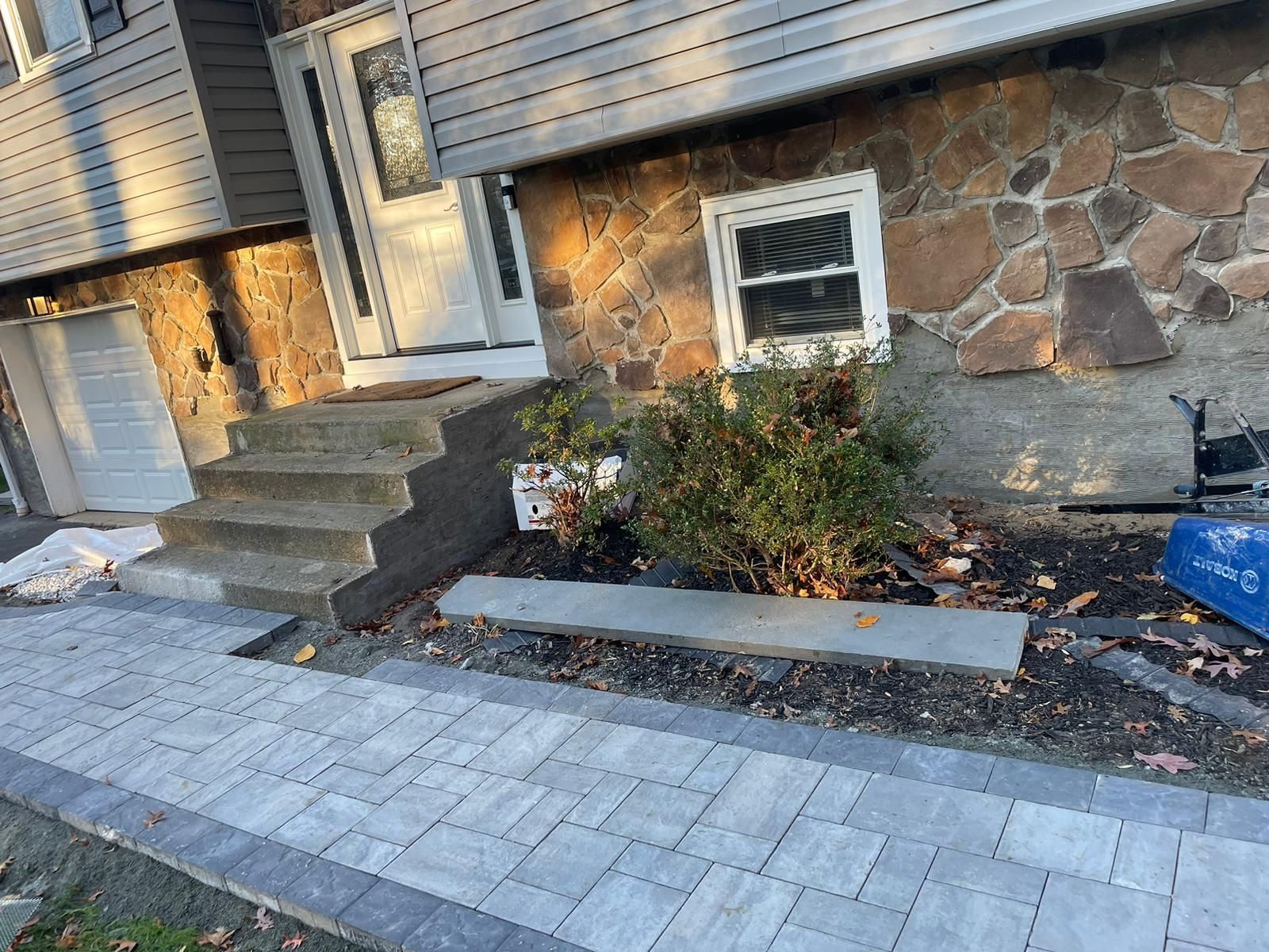 A stone house with stairs and a walkway in front of it.