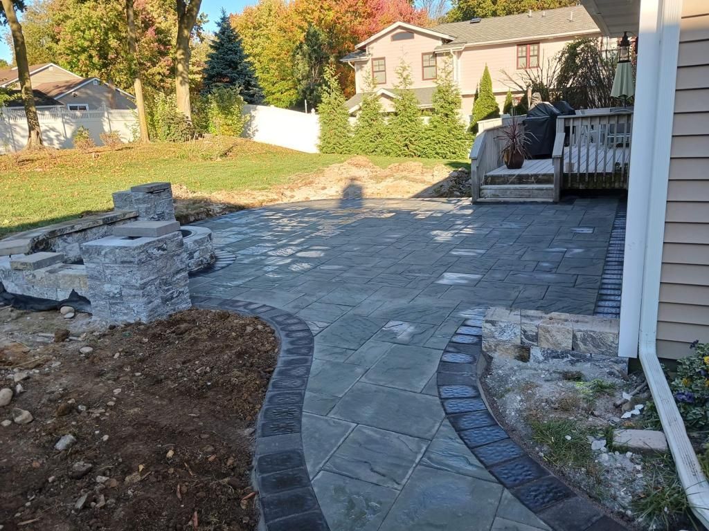 A patio is being built in the backyard of a house.