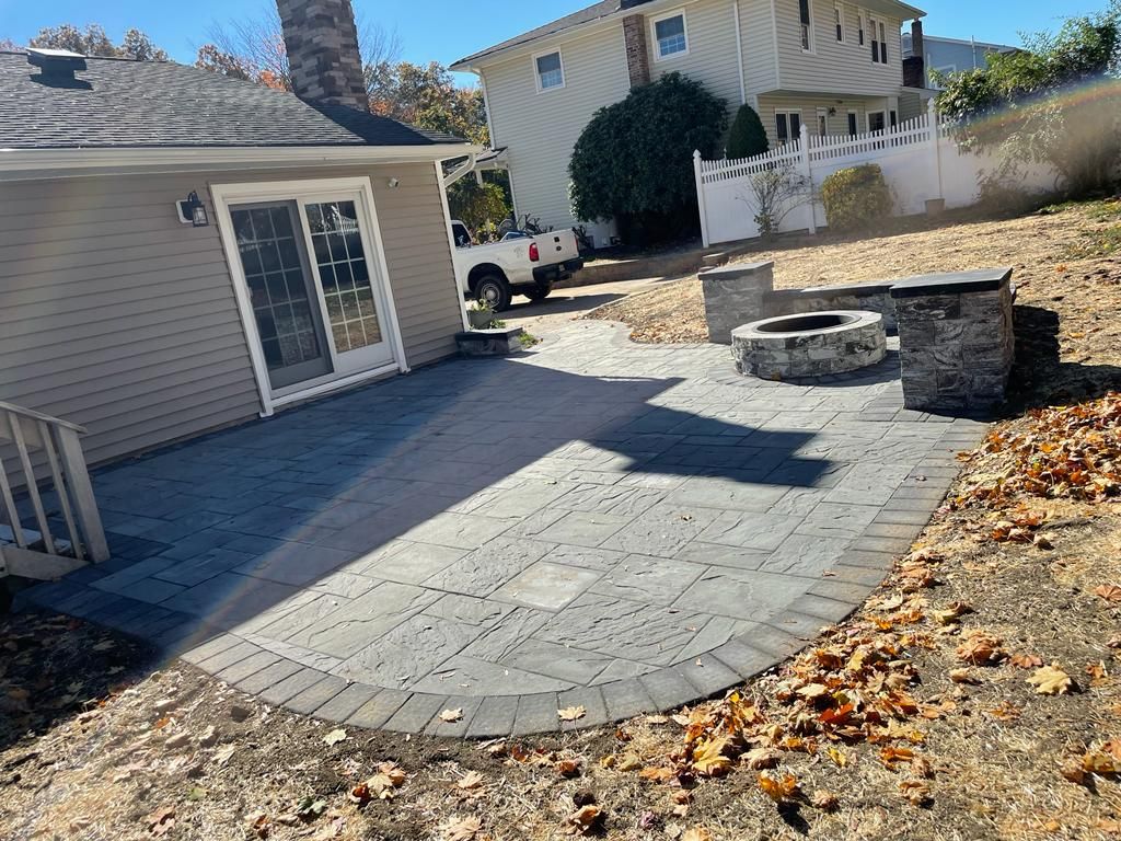 A patio with a fire pit in front of a house.