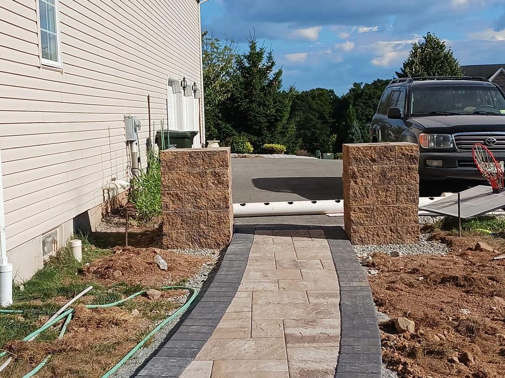 A car is parked in front of a house next to a walkway.