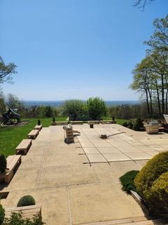 There is a large patio with a view of the ocean.