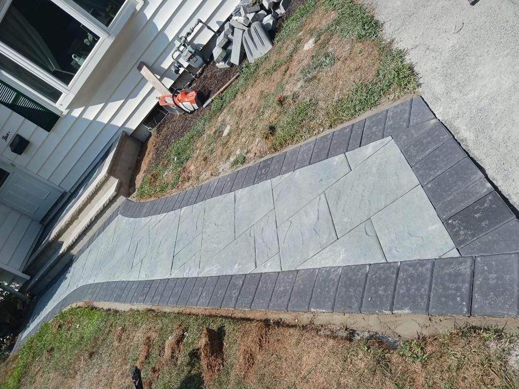 A brick walkway is being built in front of a house.