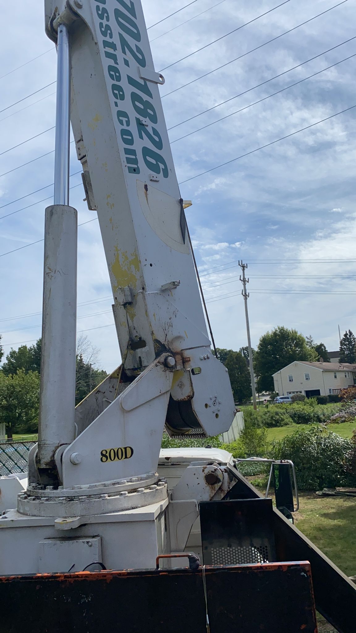 A crane with a website written on it is sitting on top of a truck.