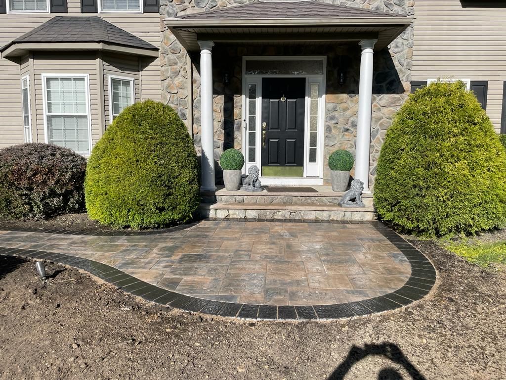 The front of a house with a brick walkway leading to the front door.