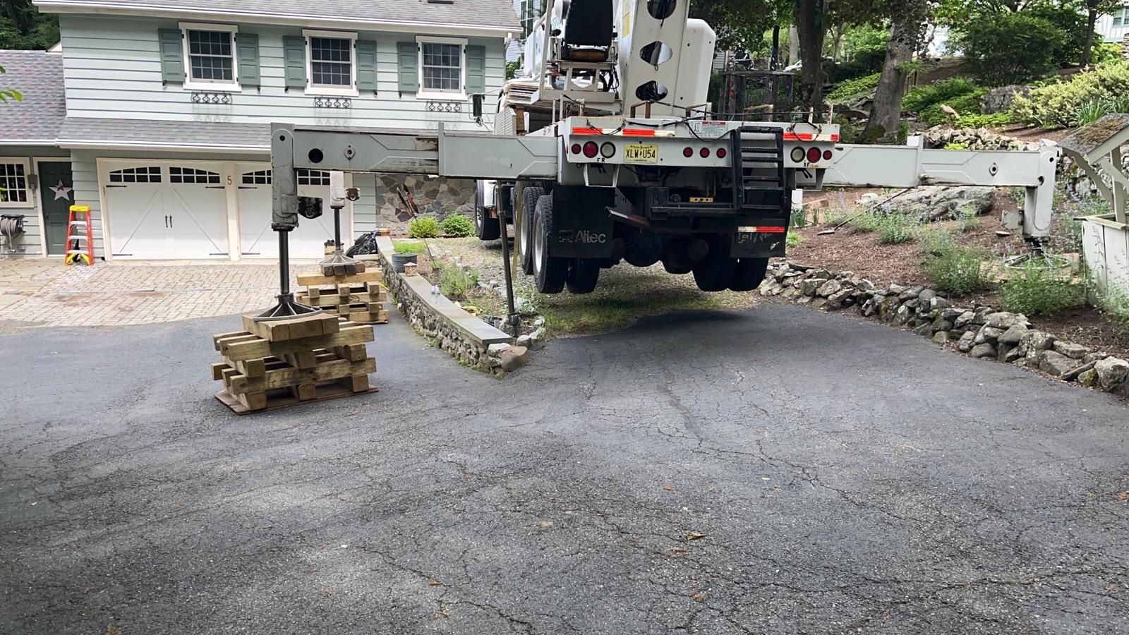 A truck is driving down a driveway next to a house.