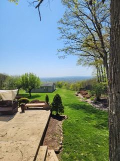 A patio with a view of a large lush green field.
