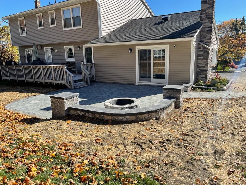 There is a fire pit in the backyard of a house.