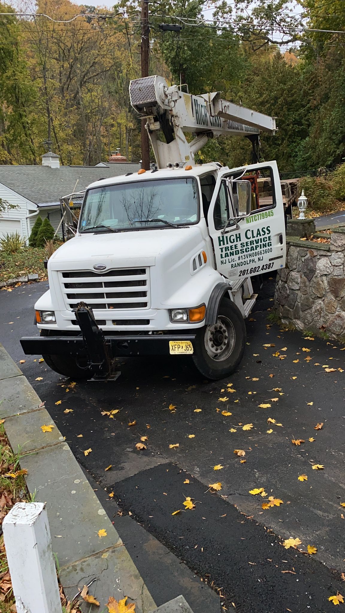 A white truck is parked on the side of a road next to a house.