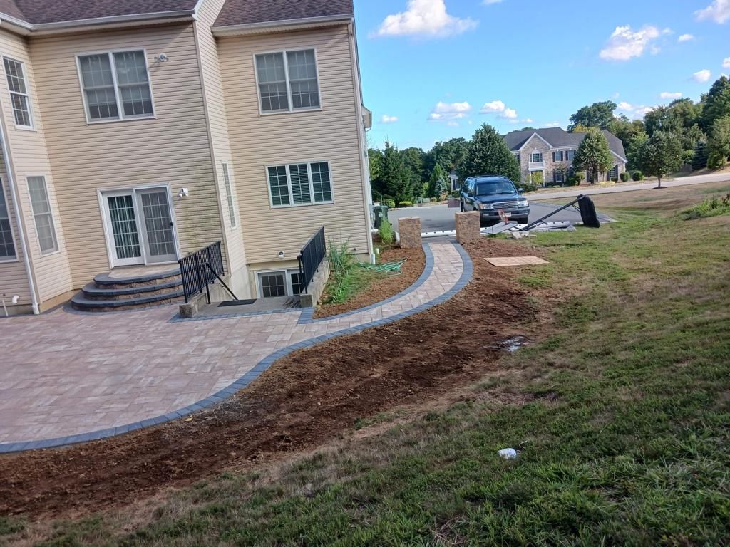 A house with a patio and a walkway in front of it.