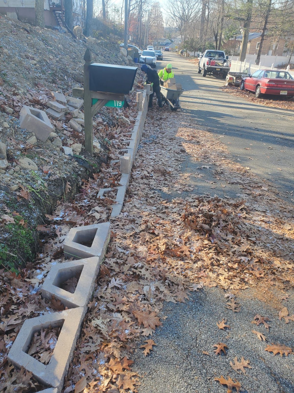A man is standing next to a mailbox on the side of a road.