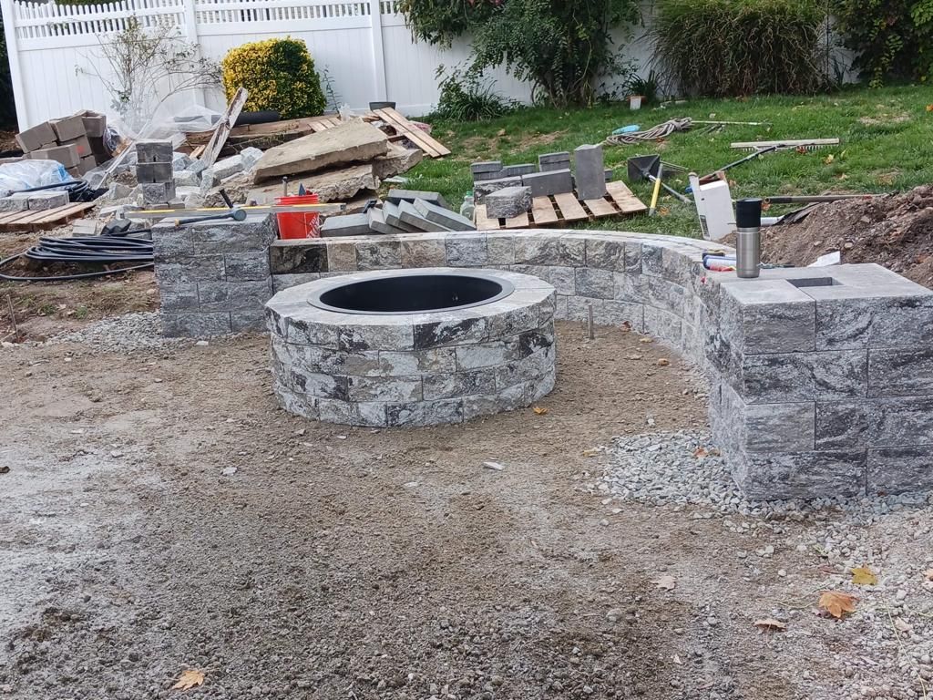 A fire pit is being built in a backyard.