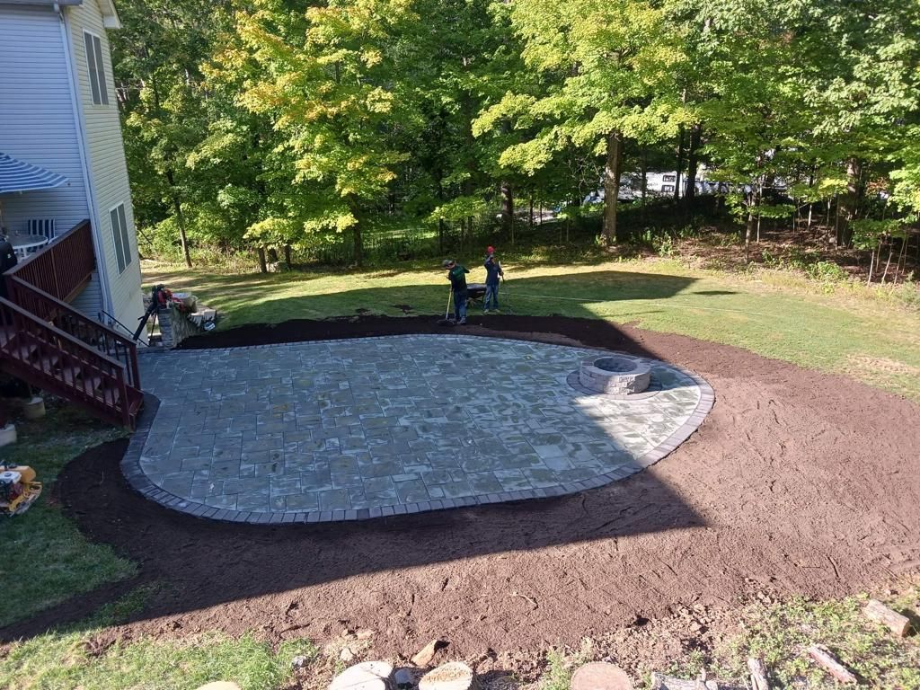 A patio is being built in the backyard of a house.