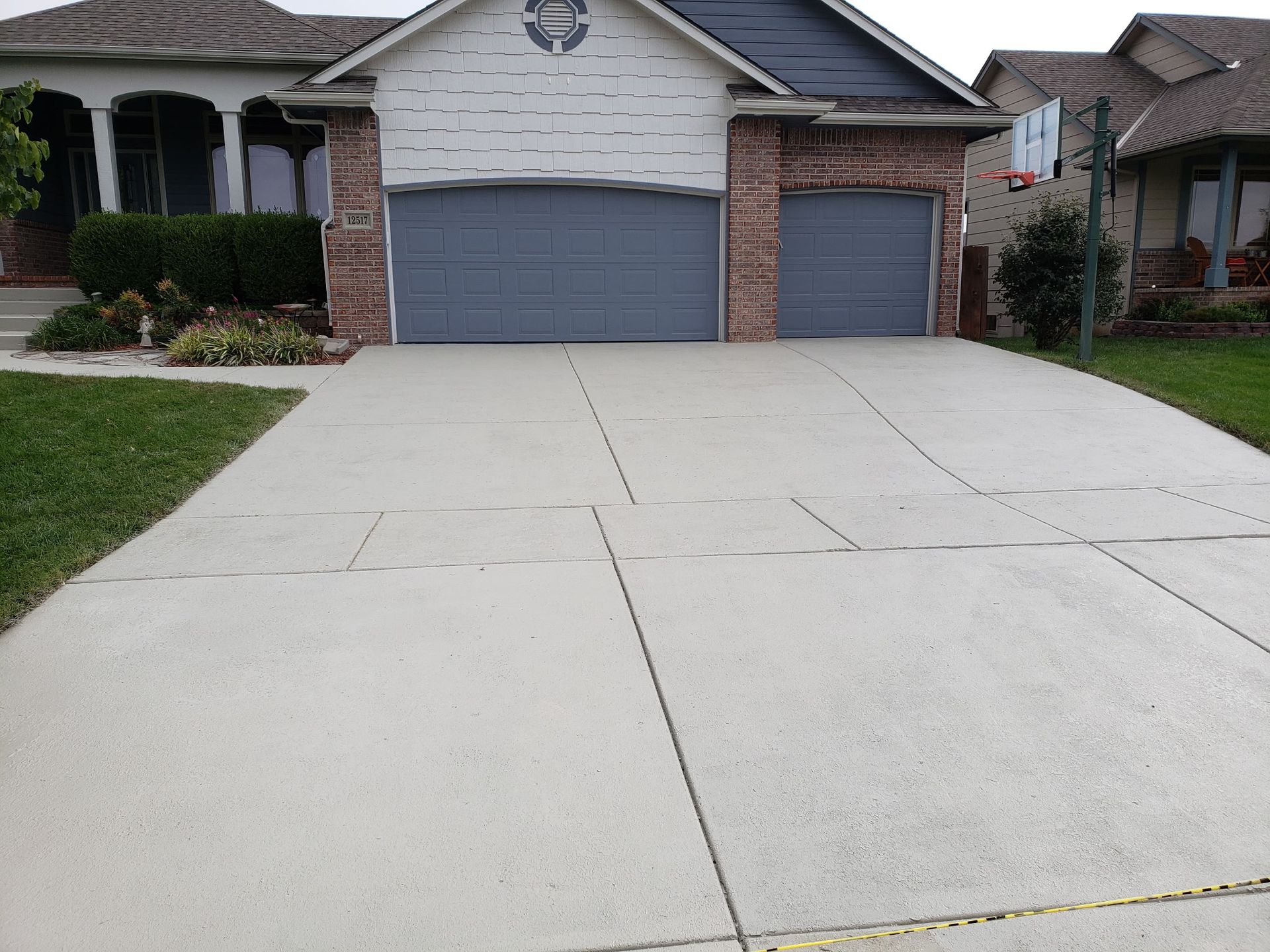 A driveway leading to a house with two garage doors