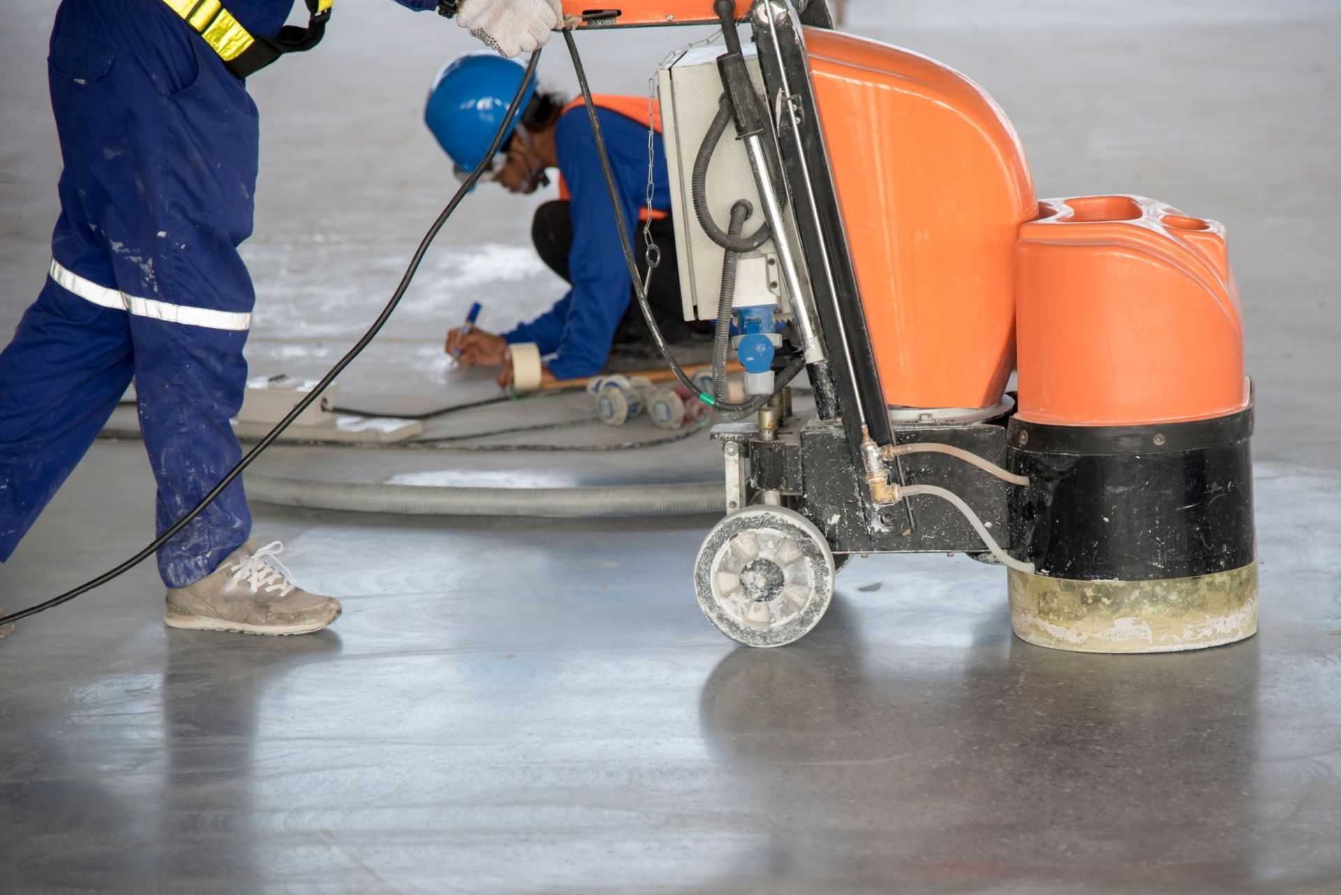 A man is using a machine to polish a concrete floor.