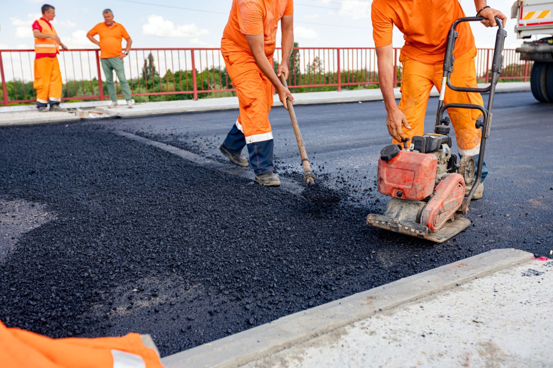 A group of construction workers are working on a road.