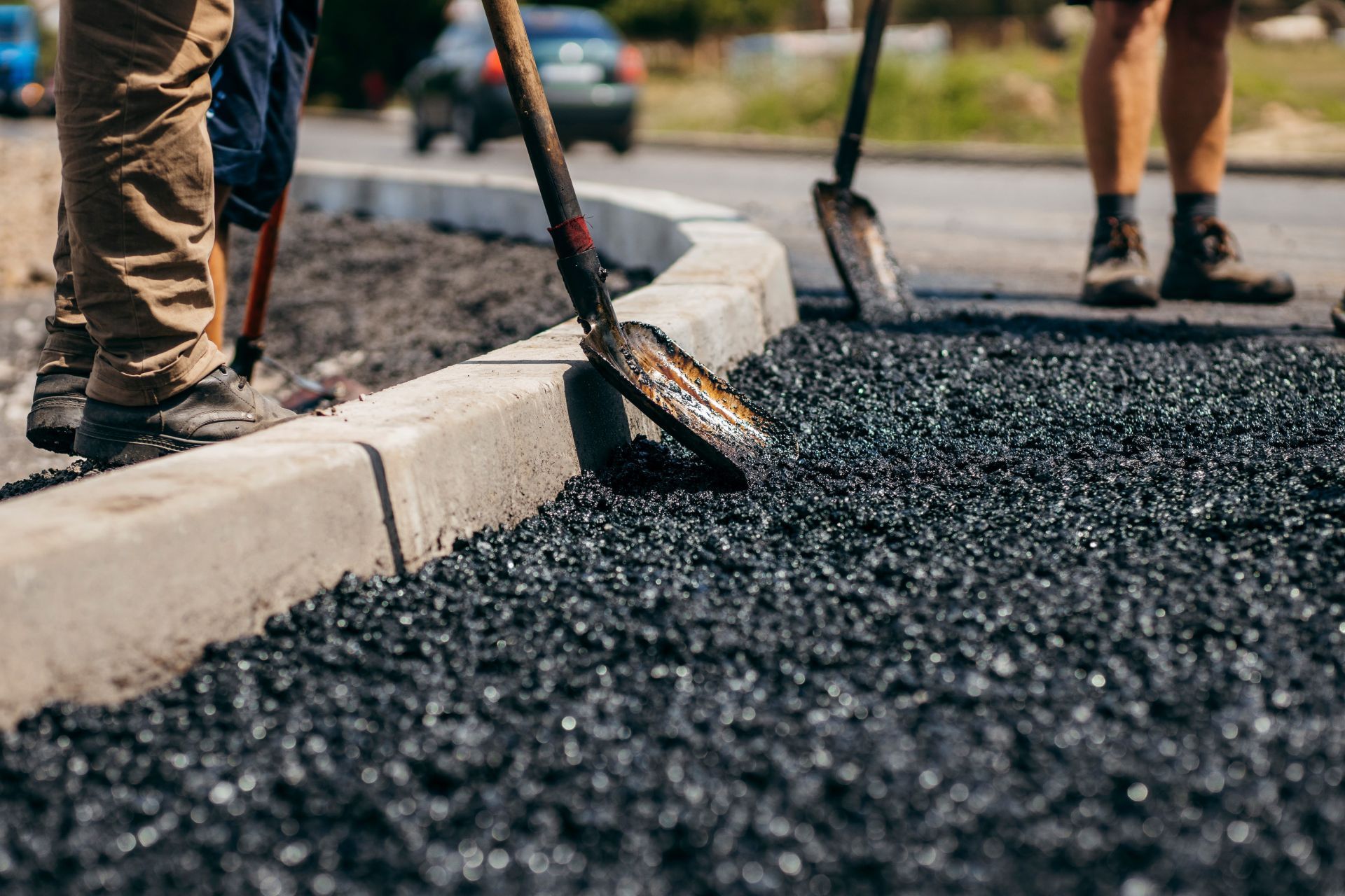 A group of people are working on a road with shovels.